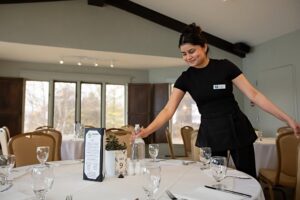 Elmhirst's Resort team member preparing the conference dining room for a hospitality industry event